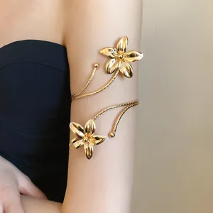 Elegant gold flower metal cuff armlet worn on the upper arm for a stylish statement.