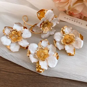 Close-up of elegant retro white oil-drop flower earrings with gold petals