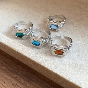 Close-up detail of vintage irregular pleated open rings featuring colorful gemstones
