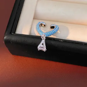 Sparkling blue zircon heart-shaped ear cuff with clear drop pendant on jewelry box