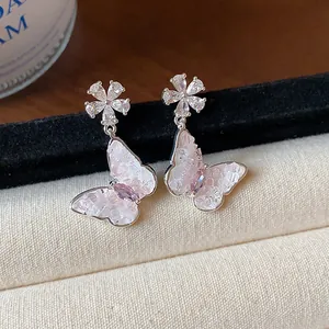 Dettaglio di orecchini a farfalla in cristallo con pietre rosa su velluto nero