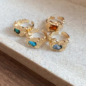 Detailed macro shot of four vintage irregular gold-textured open rings with vibrant stones