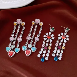 Macro view of vintage tassel earrings with colorful heart and flower zircon designs.