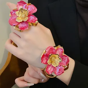 Close-up of vintage pink enamel flower ring and bracelet set with gold detailing