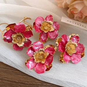 Detailed macro view of elegant vintage pink enamel flower earrings with golden centers