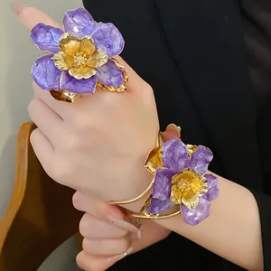 Detail of purple enamel flower ring and bracelet set in vintage gold finish on model