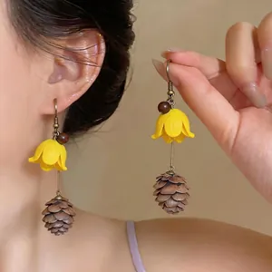 Elegant handmade summer style earrings featuring yellow flowers and realistic pinecone tassels