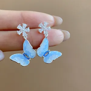 Primo piano di eleganti orecchini a farfalla in zircone con un delicato design a fiore