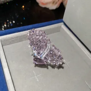 Close-up view of an elegant pink butterfly ring inside a luxury grey velvet box