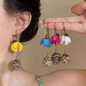 Detailed view of handmade floral pinecone tassel drop earrings in various summer colors