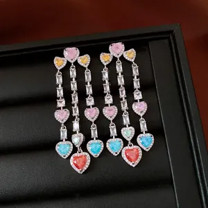 Close-up of vintage tassel earrings with multicolored heart zircons in a jewelry box