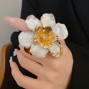 Detailed view of a vintage white enamel flower earring with gold-plated metallic center