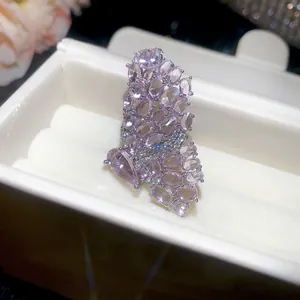 Close-up detail of an elegant micro-pave pink butterfly open ring in a jewelry box