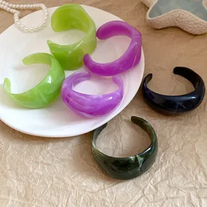 Nahaufnahme von marmorierten Harz-Manschettenarmbändern in verschiedenen Farben
