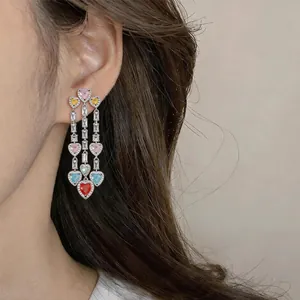 Detailed view of vintage silver needle earrings with colorful heart-shaped zircon tassels