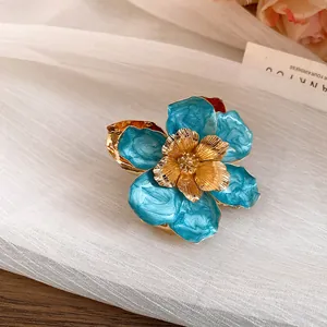 Detailed macro shot of vintage blue enamel flower earring with gold metallic stamen.