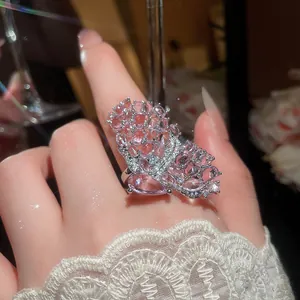 Macro detail of a silver butterfly ring with shimmering pink micro-pave stones