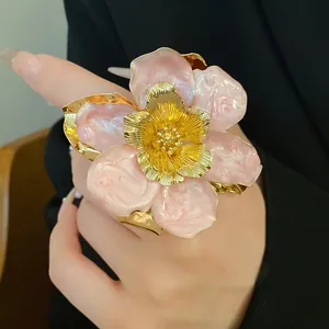 Detailed close-up view of vintage pink oil-dripped flower stud earring with gold petals