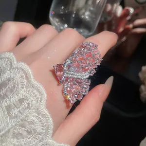 Macro view of luxury pink crystal butterfly ring on finger with intricate micro-pave detailing