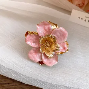 Close-up of elegant pink enamel flower stud earring with gold-toned metallic core