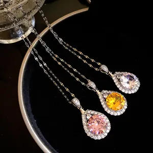 Close-up of three teardrop zircon necklaces in pink, yellow and clear white finishes.