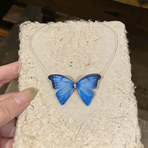 Detailed view of an elegant blue chiffon butterfly pendant necklace on a clear cord
