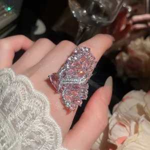 A detailed macro view showing a luxury micro-inlaid pink zircon butterfly ring on a finger