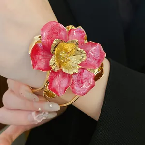 Close-up of a vintage pink enamel flower accessory with textured gold center and marbled petals.