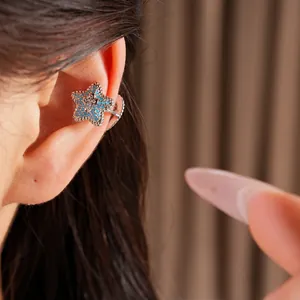 Detailed close-up view of a silver star-shaped ear cuff set with blue cubic zirconia