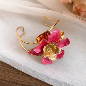 Elegant fuchsia enamel flower cuff bracelet with textured gold center and vintage finish.
