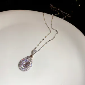 Exquisite macro shot of a pear-shaped zircon pendant necklace on a white ceramic plate