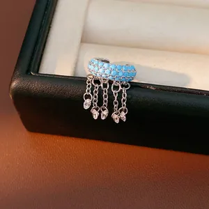 Detailed view of a light blue zircon ear cuff featuring hanging silver chains and crystals