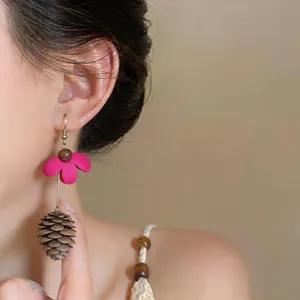 Detailed view of summer style flower earrings with pinecone tassel worn by a model