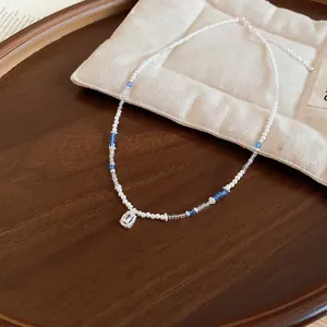 Close-up of pearl beaded necklace with a sparkling rectangular sugar cube crystal pendant