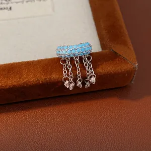 Close-up of sky blue zircon fringe ear cuff with silver chains and crystal drops