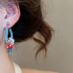 Close-up of cute mushroom and flower beaded earrings worn on ear
