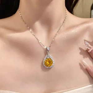 Close-up of a sparkling yellow teardrop zircon pendant necklace on a woman's neck