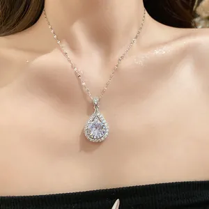 Detail view of a sparking zircon teardrop pendant necklace on a female model neck.