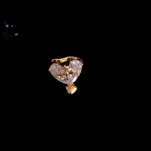 Close-up of elegant gold-tone heart ear cuff with a large clear sparkling zircon stone