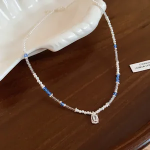 Close-up of an elegant crystal and pearl beaded necklace with an emerald-cut pendant