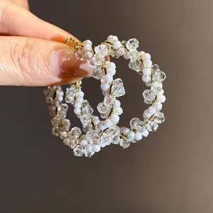 Detailed macro shot of elegant hoop earrings featuring white pearls and sparkling crystals