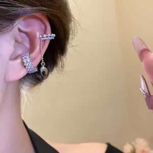Detailed macro view showing elegant zircon and pearl ear cuffs worn on a non-pierced ear