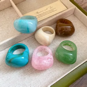 Detailed shot of marbled resin rings in various colors displayed in a jewelry tray