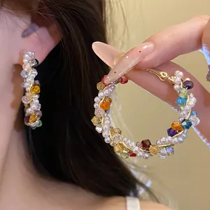 Close-up of summer dopamine style colorful crystal and pearl beaded gold hoop earrings