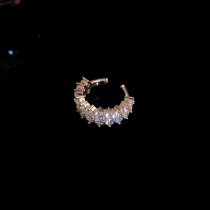 Close-up of a silver-toned ear cuff encrusted with sparkling cubic zirconia stones.