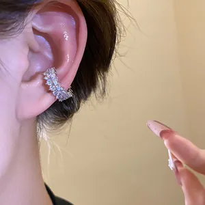 Detailed close-up of sparkling cubic zirconia ear cuff on ear, non-pierced earring.