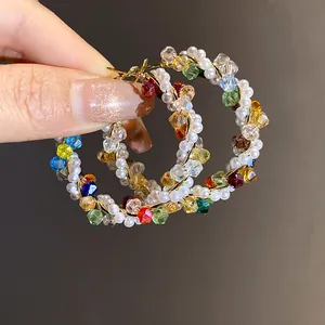 Detail shot of colorful dopamine style crystal and white pearl beaded hoop earrings for women