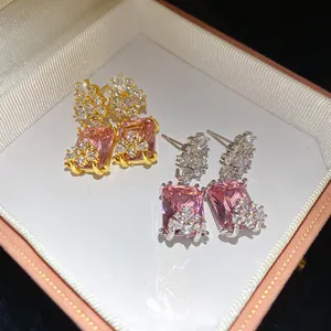 Macro view of vintage-style pink square earrings with zircon accents in a gift box.