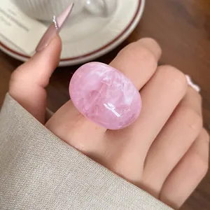 Close-up of a pink marbled resin ring showing elegant swirled patterns and texture