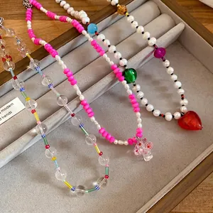 Handmade freshwater pearl necklace with heart and mushroom charms in a jewelry tray